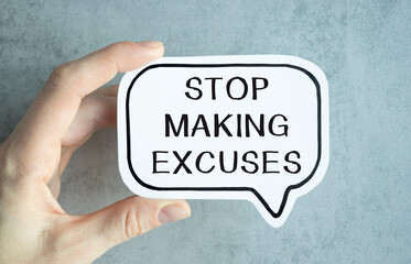 Closeup on businessman holding a card with text STOP MAKING EXCUSES, business concept image with soft focus background and vintage tone