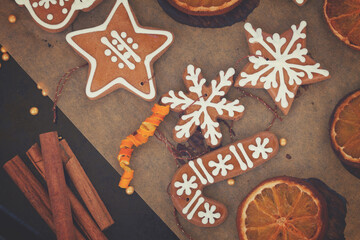 christmas baked gingerbread snowflakes cookies with evergreen twigs on wood, color of the year 2025 mocha mousse