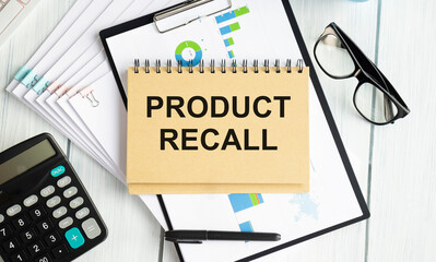 text product recall written on a blue background near a magnifying glass and and a calculator.