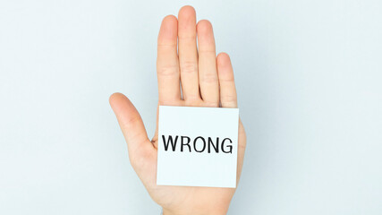 A business man holding a paper in front of his face with the text wrong