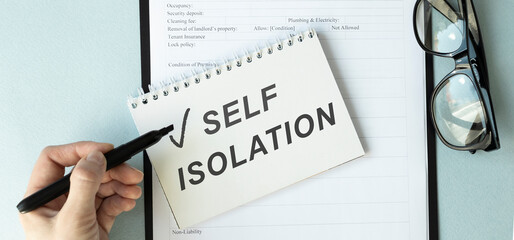 Text on notepad SELF ISOLATION. The concept of quarantine or self-isolation in connection with the...