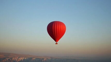 A Single Red Hot Air Balloon Soaring Over Scenic Landscape