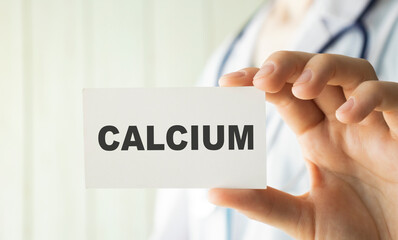 Doctor holding a card with text CALCIUM, medical concept.
