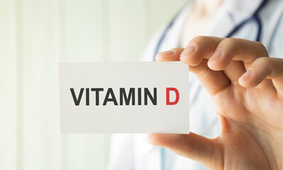 Vitamin D written on a card in doctors hands