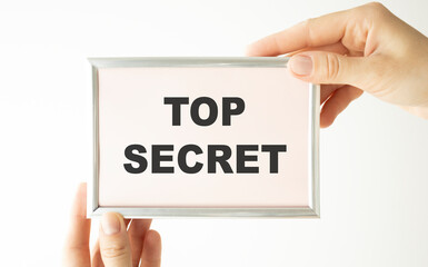 Top Secret text on hands give envelope background.
