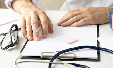 Getting ready for consultation. Dark-haired bearded doctor in a white robe looking involved