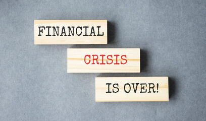 financial crisis is over text on wooden block