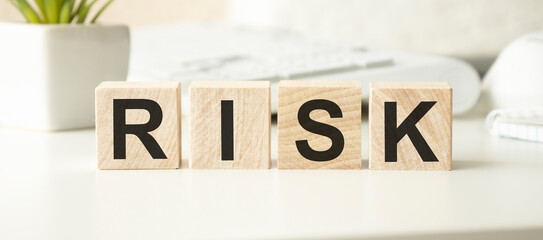 Risk assessment, decision to accept business result in uncertainty, unpredictable situation concept, cube wooden block with alphabet building the word RISK.