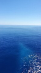 Fototapeta premium Vast Ocean Horizon: A captivating view of the endless blue expanse, where sky meets sea, creating a serene and tranquil atmosphere. The deep azure hues evoke a sense of peace and tranquility.