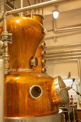 Distillate production process in copper distillation unit. Cpper vacuum still for distillation performed under reduced pressure for gin production.