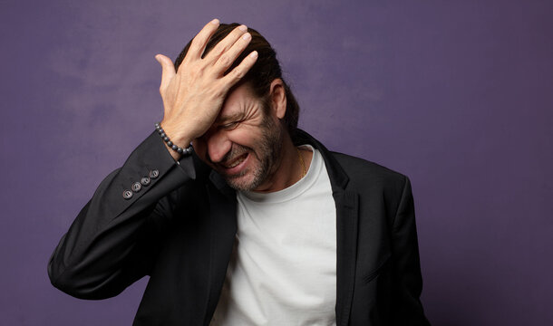 laughing and slapping forehead like saying d&rsquo;oh! I forgot or that was a stupid mistake
