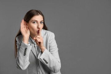 Woman showing hand to ear gesture on grey background, space for text