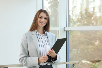 Portrait of banker with clipboard in office. Space for text