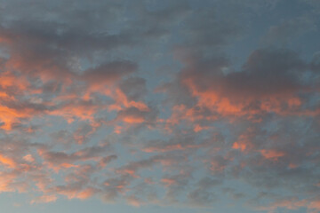 blue sky with pink clouds at dusk as sun sets 