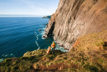 Selbstklebende Fototapeten A fine art landscape drone photograph of a woman with a dog standing on a cliff at Elk Flats along the Oregon Coast on a sunny day © Victoria Nefedova