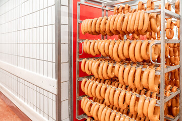 Sausage production line showing smoked sausages hanging in a modern food processing facility