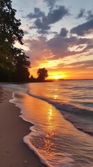 Naklejka premium Golden Hour Beachscape: A captivating sunset paints the sky with fiery hues, casting a warm glow on the tranquil beach, where gentle waves lap at the shore, creating a serene and breathtaking scene. 