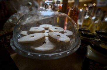 Traditional Linzer cookies displayed under a glass dome at a Christmas market.