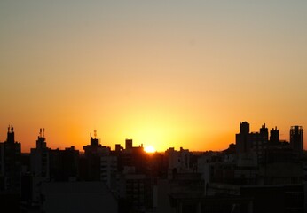 pasaje urbano amaneciendo contorno y siluetas de los edificios y el sol apareciendo