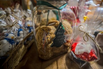 Close-up of Christmas cookies in a glass jar with festive decorations at a Christmas market.