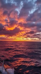 Obraz premium Ocean Sunset: Fiery hues paint the sky as the sun dips below the horizon, casting a breathtaking glow over the vast, rippling ocean. The scene evokes a sense of tranquility and wonder.