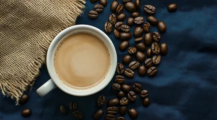 Une tasse de café et des grains sur un fond bleu foncé avec un sac en toile de jute, vus de haut, image avec espace pour texte.