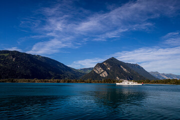 lake thun with surrounding hills in bernese oberland switzerland with boat during summer with blue cloudy sky