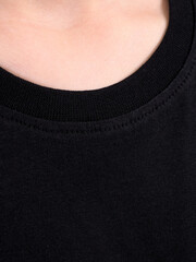 Black t-shirt on a person. Simple black t-shirt design. Close-up of black t-shirt fabric. Minimalist black t-shirt style.