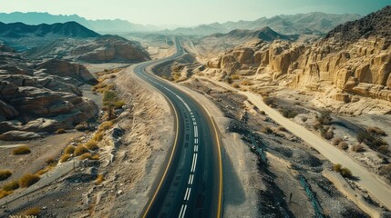 A drone shot of a biker winding along a serpentine mountain path, the road carving through the majestic landscape. Dynamic and dramatic composition, with copy space