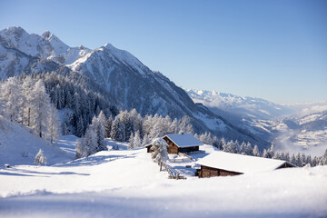 Winter nature landscape with snow covered authentic hut in the Alps. Winter wonderland concept