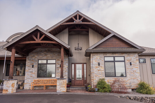 Front of modern house with stone veneer siding and arched roof