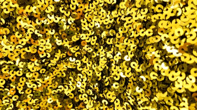 Golden sequin fabric with shimmering highlights luxurious textured background for design.Holiday abstract glitter texture with blinking lights.4K video