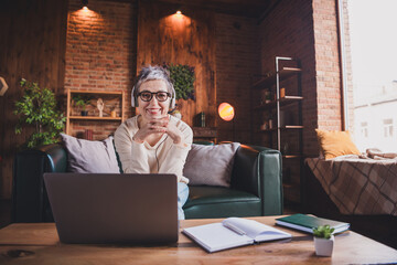 Charming elderly woman with short grey hair smiling in casual pullover while enjoying leisure time...