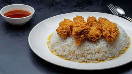 Fried rice with chicken. Prepared and served in a wok. Natural wood in the background.