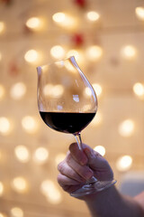 a glas of wine and christmas lights