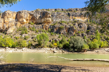 Fototapeta premium Hoces del Rio Duraton Nature Reserve (Parque Natural de las Hoces del Río Duratón) with limestone vertical cliffs with layers, winding river and lush green vegetation.