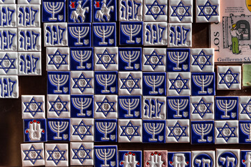 Souvenir shop display with white and blue fridge magnet tiles with Jewish symbols: menorah, Star of...