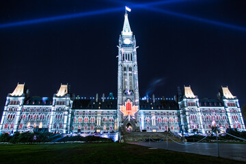 Fototapeta premium A large building with a clock tower and a large red maple leaf on the roof