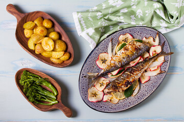 Grilled mackerel fish with roasted potatoes and broccoli. View from above, top studio shot