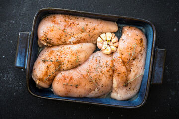 Chicken fillet, raw chicken meat breast with spices and garlic in the pan. Top view.