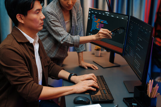 IT developers discussing with point to intelligent website development coder system running data online two screens information technology at neon light room at modern office. Infobahn.