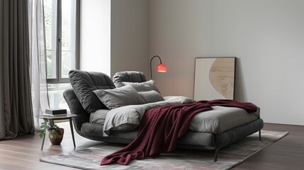 Minimalist bedroom featuring a charcoal bed frame, grey linens, and burgundy throw in a stylish setting.