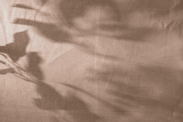 Aesthetic natural floral sunlight shadows on crumpled linen textured fabric background in soft warm...