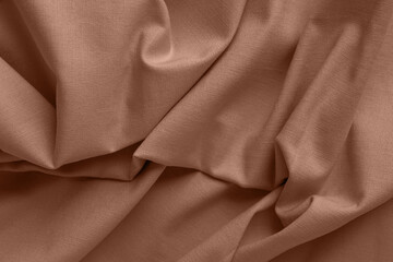 Textured folds of linen fabric in beige, brown color
