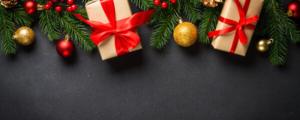 Christmas background with christmas tree, present box and holidays decorations at black. Flat lay...