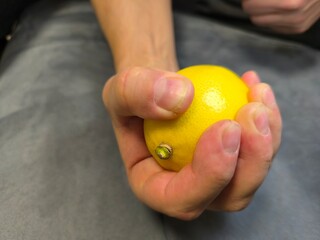 Hands holding a fresh lemon