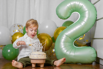 Toddler Celebrating Second Birthday with Cake and Balloons