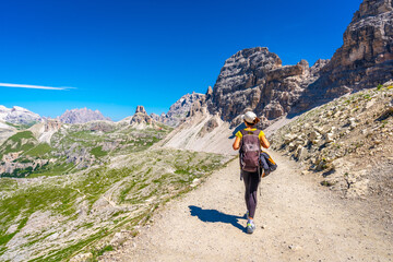 Naklejka premium Tourist walking on the tre cime di lavaredo trail in the dolomites, italy
