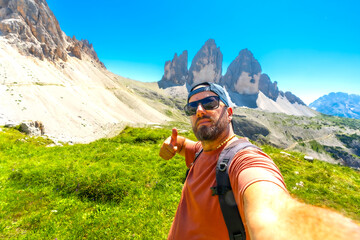 Tourist hiking in tre cime di lavaredo making thumbs up sign in summer
