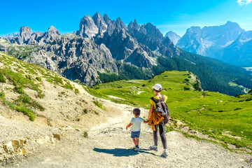 Fototapeta premium Mother and son hiking on scenic trail in tre cime di lavaredo, dolomites, italy
